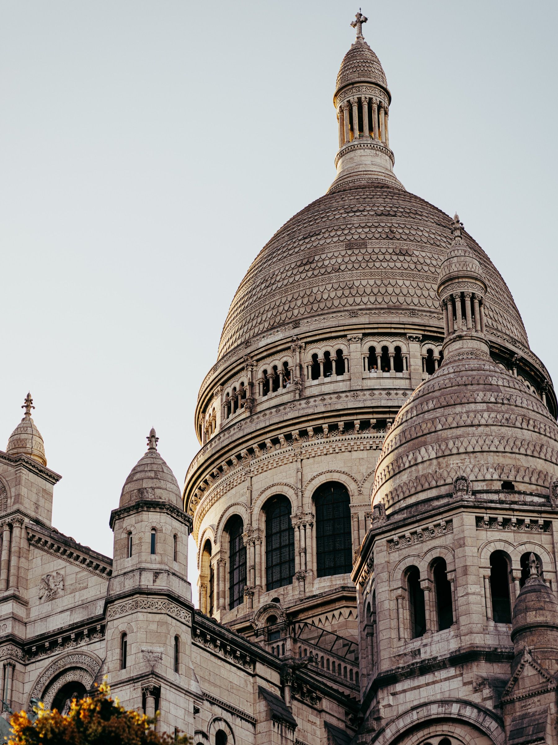 The pale domes of the Sacré-Cœur against a clear sky.